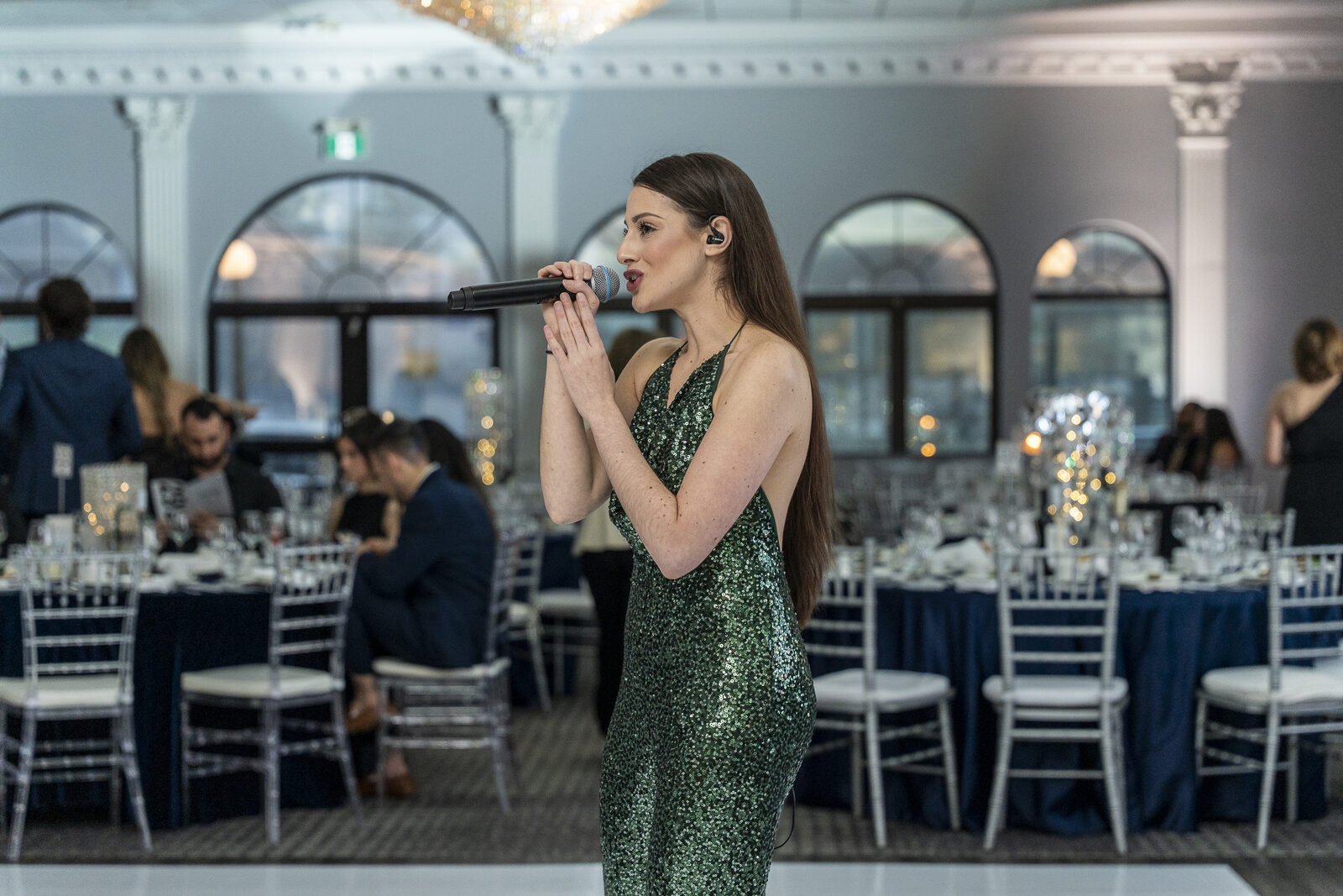 Regina Bianca performing in an elegant ballroom as guests gather